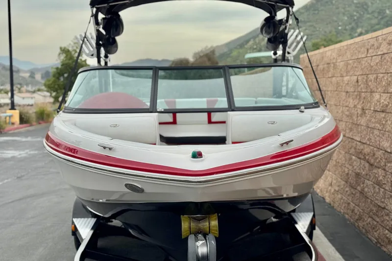 Slide: The Image of 2017 Regal 2000 ESX Bowrider boat on trailer, parked near a brick wall. - 2