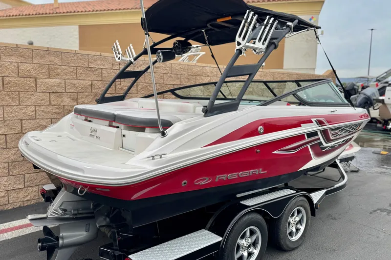 Slide: The Image of 2017 Regal 2000 ESX Bowrider boat with red and white design on a trailer. - 5