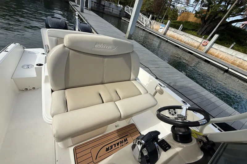 Slide: The Image of 2018 Boston Whaler 270 Dauntless boat interior with helm and seating at dock. - 12