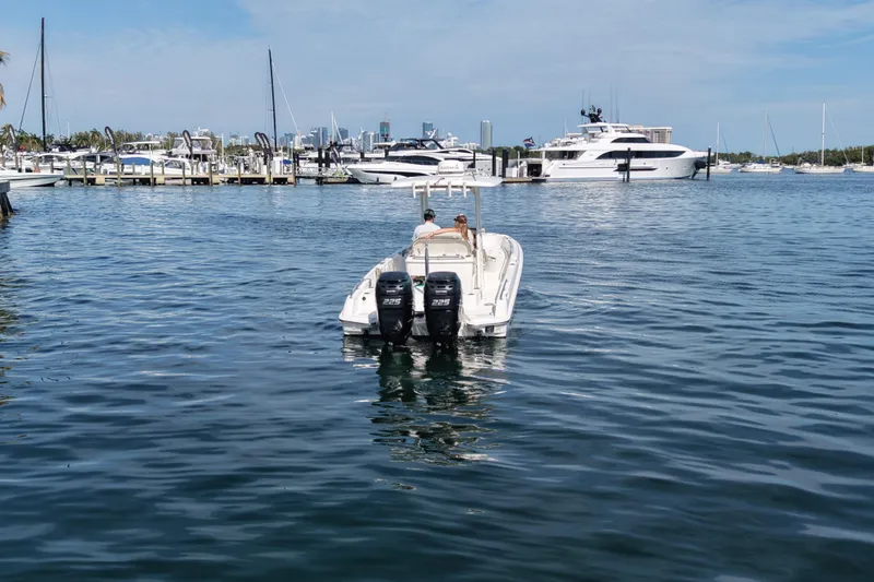 Slide: The Image of 2018 Boston Whaler 270 Dauntless boat on calm marina waters, surrounded by yachts. - 4