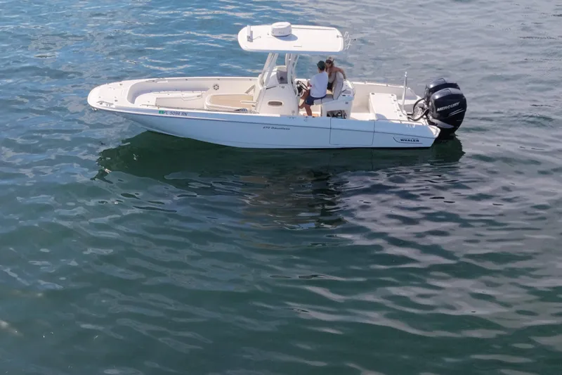 Slide: The Image of 2018 Boston Whaler 270 Dauntless boat on calm water with two people onboard. - 8