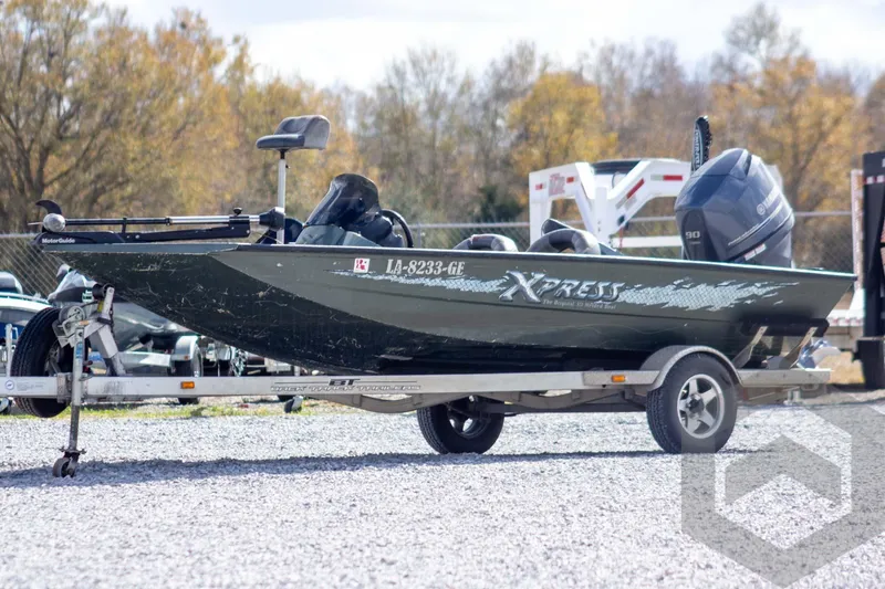 The Image of 2015 Xpress H17 boat on trailer with outboard motor, parked on gravel. - 1