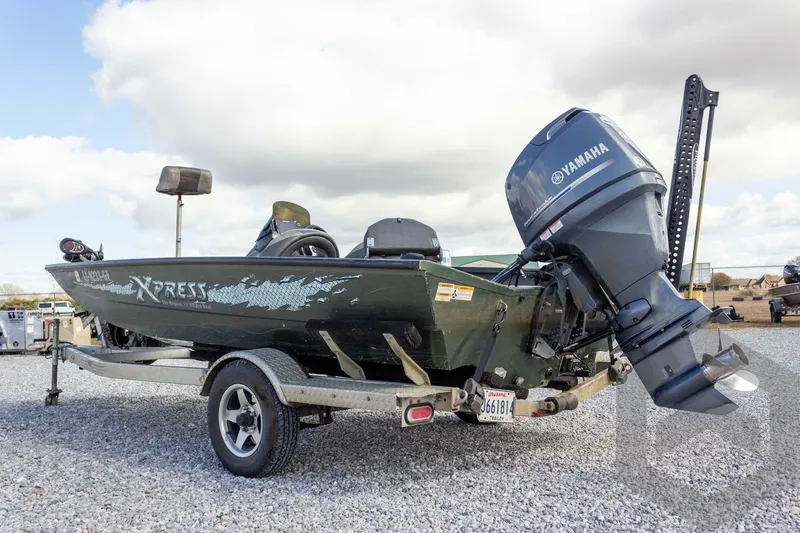 Slide: The Image of 2015 Xpress H17 boat with Yamaha motor on a trailer, parked on gravel. - 11