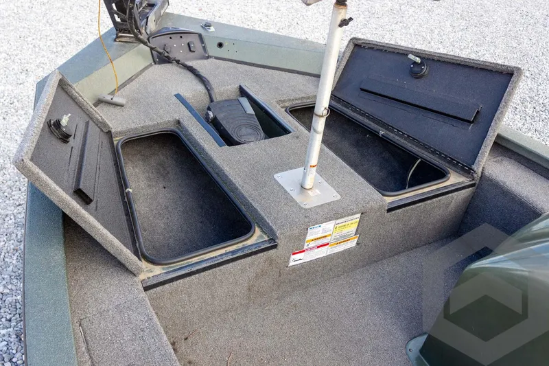 Slide: The Image of 2015 Xpress H17 boat interior with open storage compartments on a gravel surface. - 14