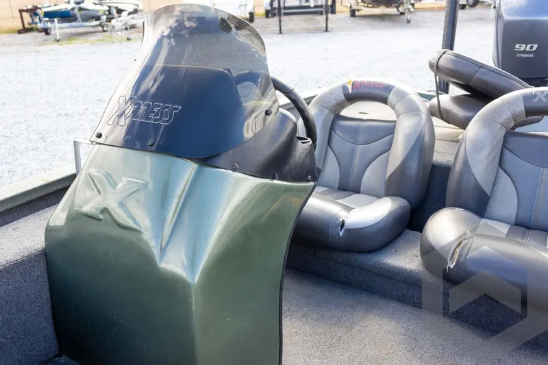 Slide: The Image of 2015 Xpress H17 boat interior with steering console and cushioned seats. - 18