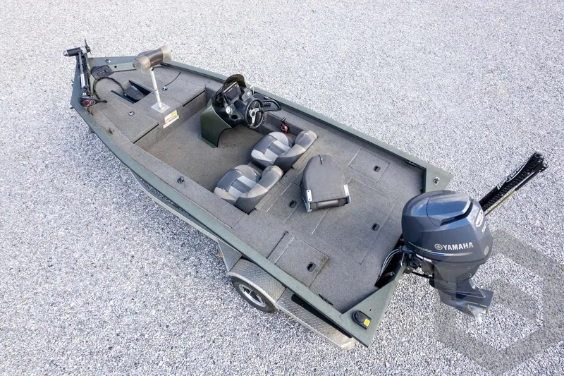 Slide: The Image of 2015 Xpress H17 boat with Yamaha motor, gray interior, and dual seats on gravel surface. - 31