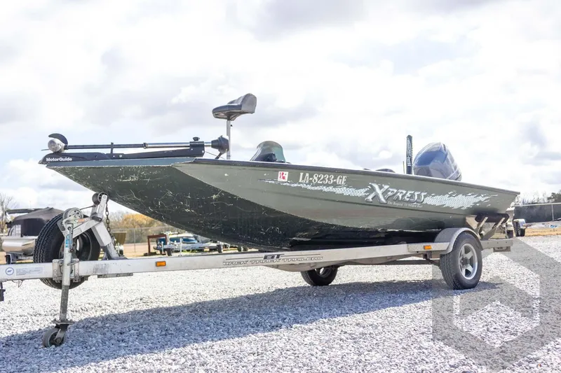 Slide: The Image of 2015 Xpress H17 boat on trailer, featuring MotorGuide trolling motor, parked on gravel. - 5
