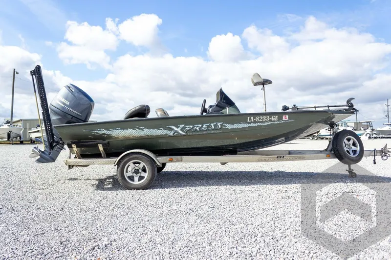 Slide: The Image of 2015 Xpress H17 boat on trailer, featuring Yamaha outboard motor, parked on gravel lot. - 8