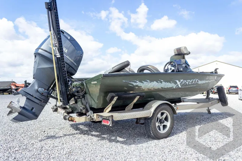Slide: The Image of 2015 Xpress H17 boat on trailer with Yamaha outboard motor, parked on gravel. - 9