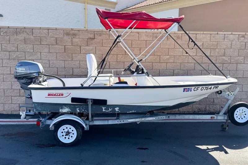 The Image of 2000 Boston Whaler 13 Sport boat with red canopy on trailer, Yamaha motor attached. - 0