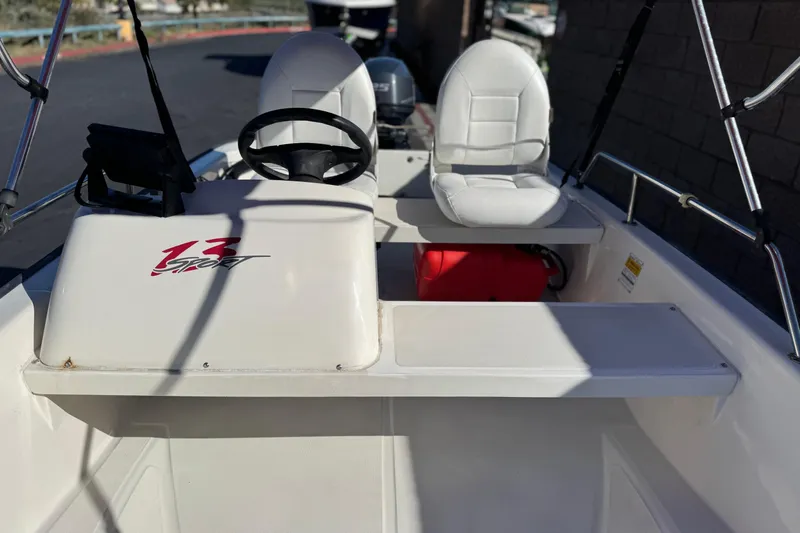 Slide: The Image of 2000 Boston Whaler 13 Sport boat interior with steering wheel and seating. - 11
