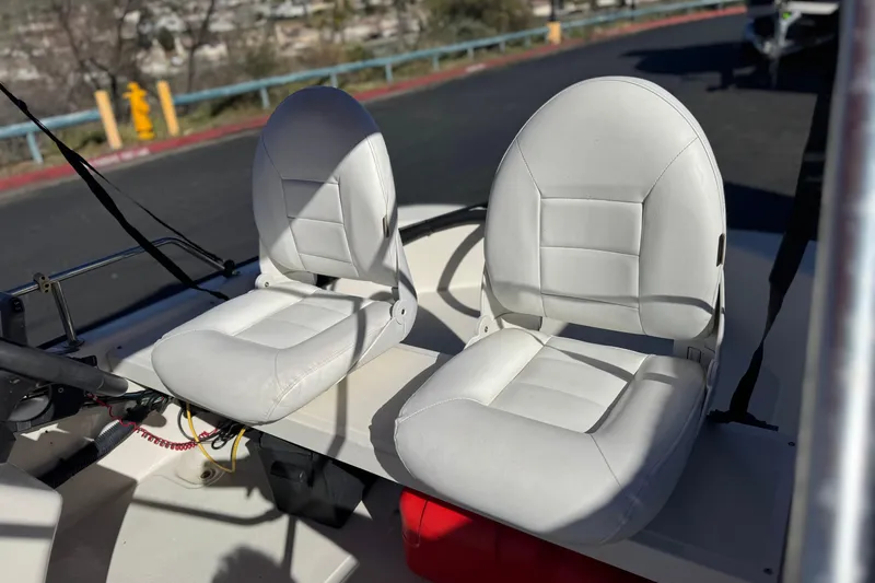 Slide: The Image of 2000 Boston Whaler 13 Sport boat with white cushioned seats, steering wheel visible. - 12