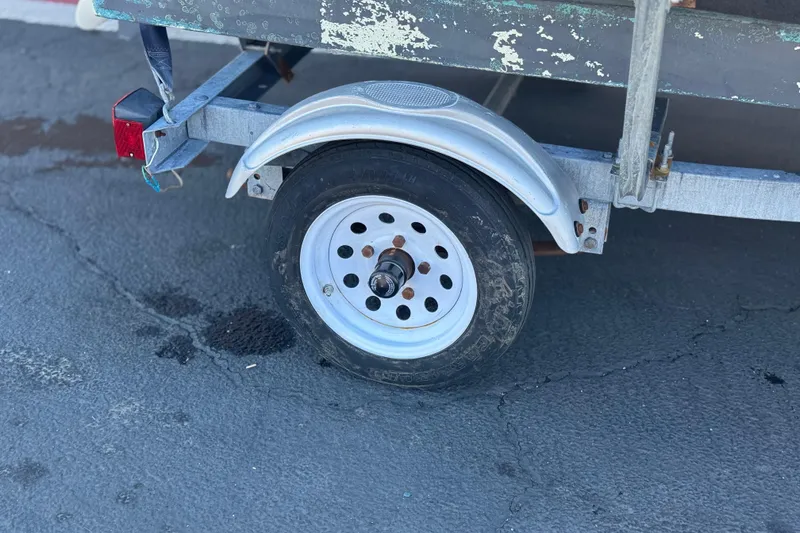 Slide: The Image of Trailer wheel of a 2000 Boston Whaler 13 Sport boat on pavement. - 19