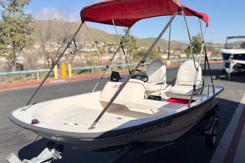 Slide: The Image of 2000 Boston Whaler 13 Sport boat with red canopy on a trailer. - 3