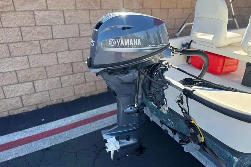 Slide: The Image of 2000 Boston Whaler 13 Sport with Yamaha outboard motor, parked near brick wall. - 6