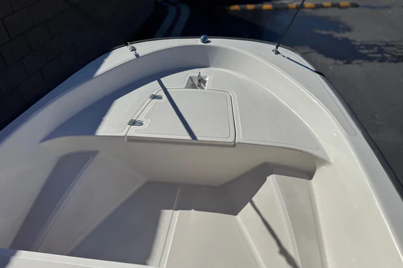 Slide: The Image of 2000 Boston Whaler 13 Sport boat interior, featuring a clean, white deck and storage compartment. - 9