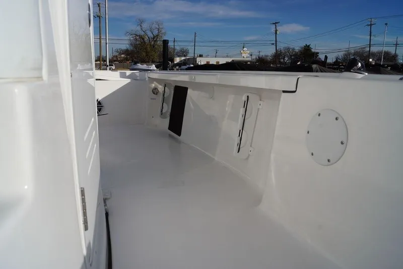 Slide: The Image of 2026 Tidewater 2410 Bay Max boat interior, showcasing sleek white deck and storage compartments. - 13