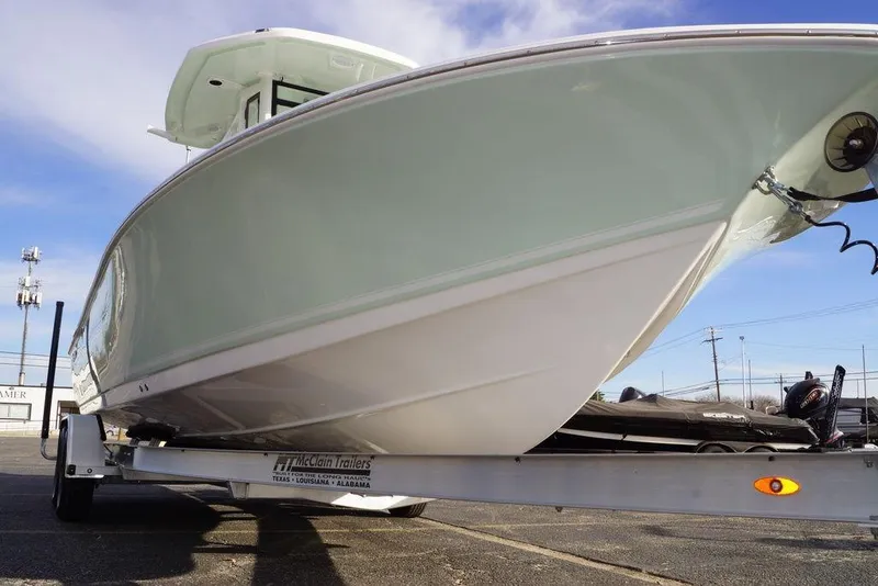 Slide: The Image of 2026 Tidewater 2410 Bay Max boat on trailer, viewed from below, against blue sky. - 4