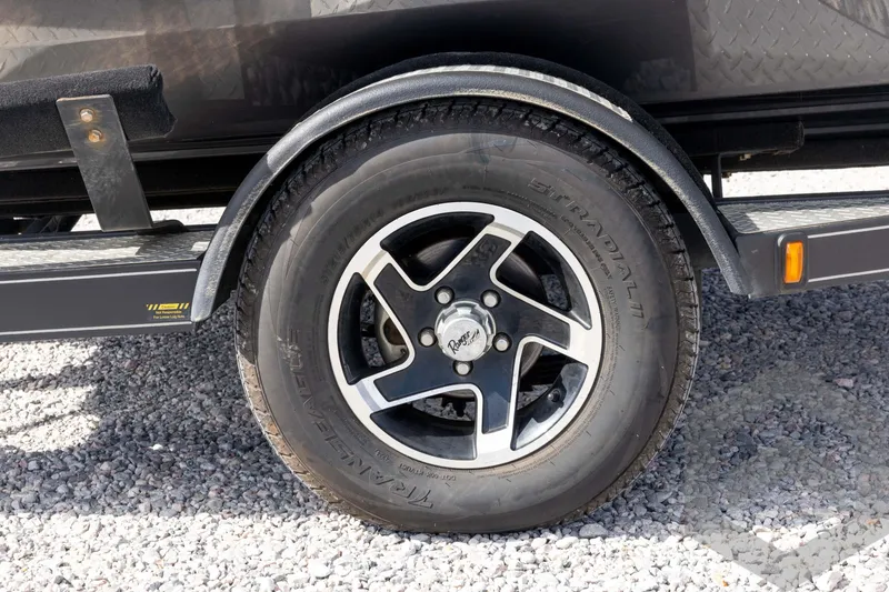 Slide: The Image of 2020 Ranger RT188P trailer wheel on gravel surface, featuring black and silver alloy rim. - 15