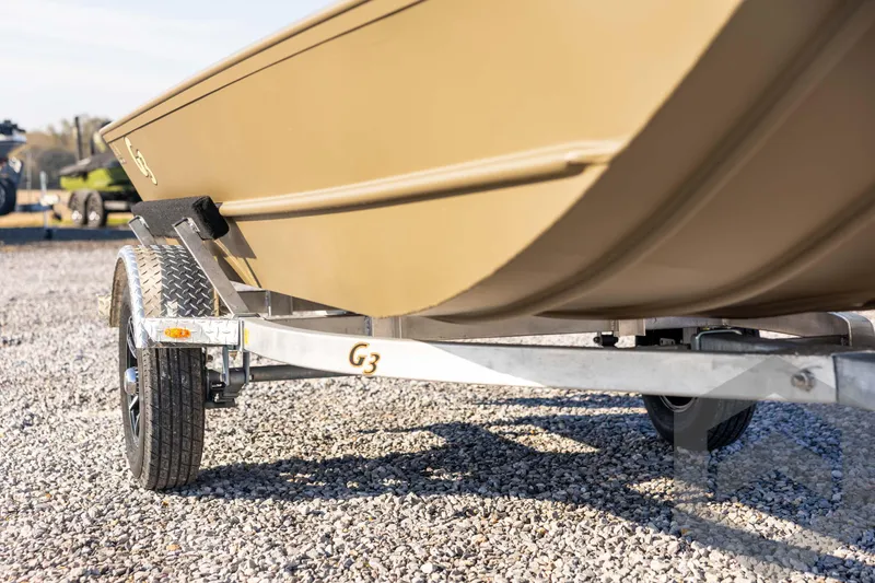 Slide: The Image of 2026 G3 Gator Tough 1548 VBW boat on trailer, parked on gravel. - 12
