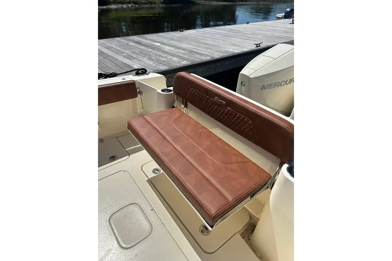 Slide: The Image of 2025 Scout 277 LXF boat with brown leather seating and Mercury engine at dock. - 16
