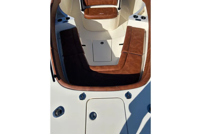 Slide: The Image of 2025 Scout 277 LXF boat interior with brown cushioned seating and cup holders. - 21