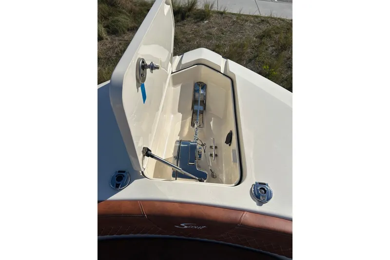Slide: The Image of 2025 Scout 277 LXF boat anchor compartment with open hatch, showcasing storage space. - 23