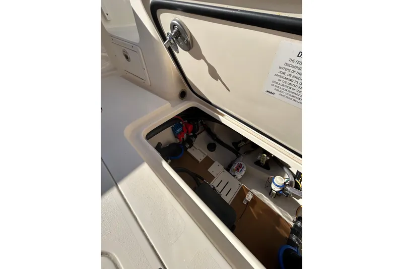 Slide: The Image of 2025 Scout 277 LXF boat storage compartment with visible wiring and components. - 24
