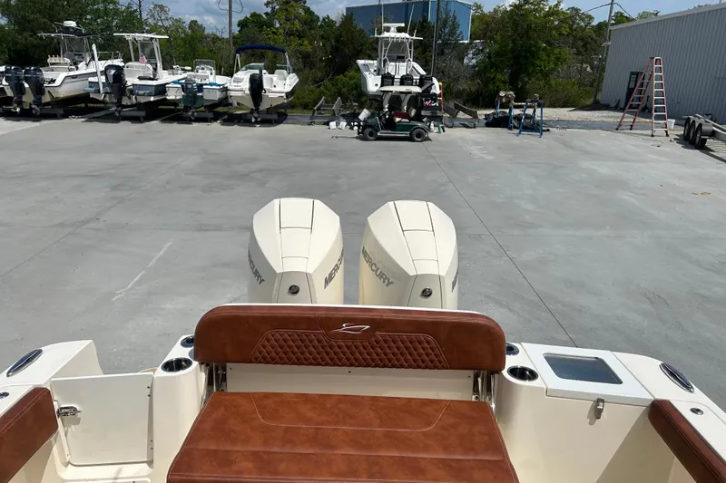 Slide: The Image of 2025 Scout 277 LXF boat with dual Mercury engines in a marina setting. - 28