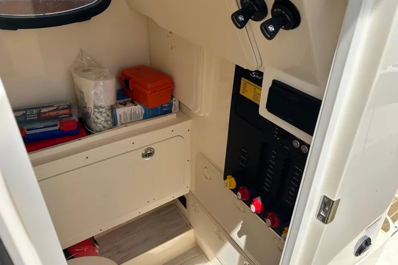 Slide: The Image of Interior storage of 2025 Scout 277 LXF boat with control panel and supplies. - 29