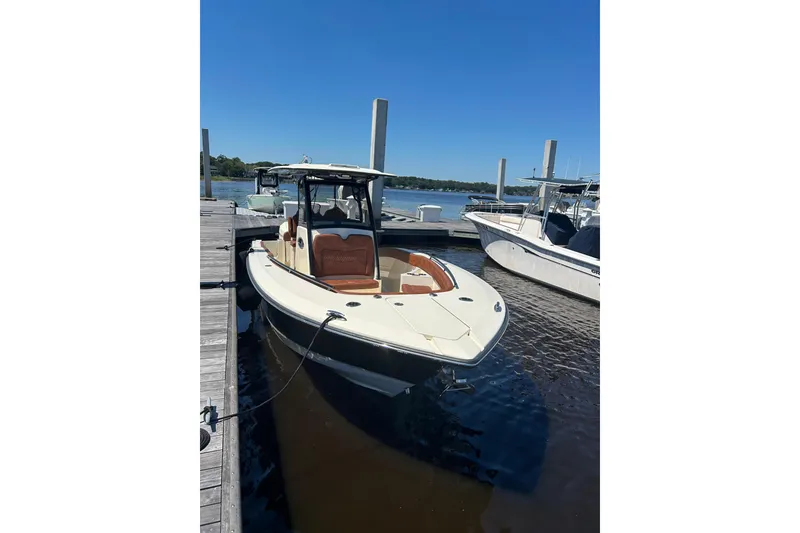 Slide: The Image of 2025 Scout 277 LXF boat docked at marina under clear blue sky. - 32