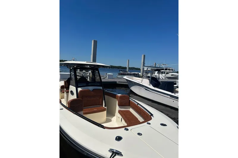 Slide: The Image of 2025 Scout 277 LXF boat docked at marina under clear blue sky. - 38