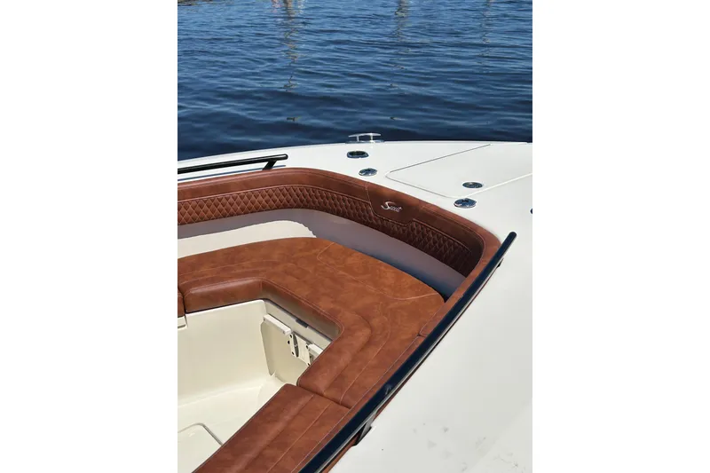Slide: The Image of 2025 Scout 277 LXF boat with luxurious brown leather seating on calm water. - 43