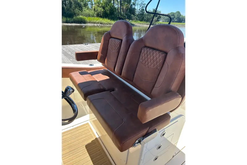 Slide: The Image of Luxurious brown leather seating on 2025 Scout 277 LXF boat, docked by a serene river. - 44