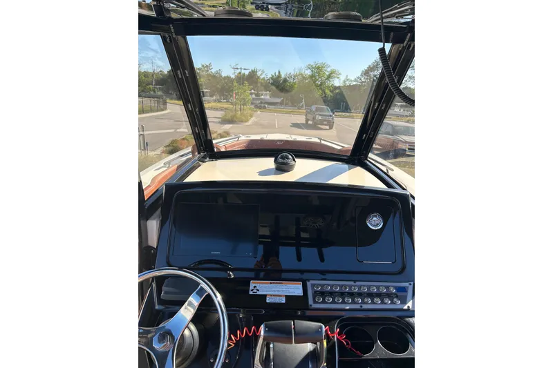 Slide: The Image of Interior view of 2025 Scout 277 LXF boat dashboard with steering wheel and controls. - 50