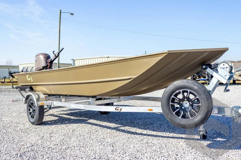 Slide: The Image of 2026 G3 Gator Tough 1652 VBW boat on trailer, parked on gravel lot. - 13