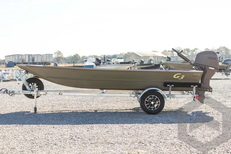 Slide: The Image of 2026 G3 Gator Tough 1652 VBW boat on trailer, side view in outdoor setting. - 19