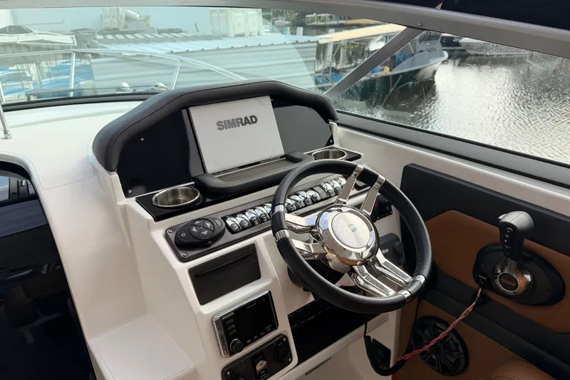Slide: The Image of 2019 Rinker EX 290 boat helm with Simrad display and modern controls. - 4