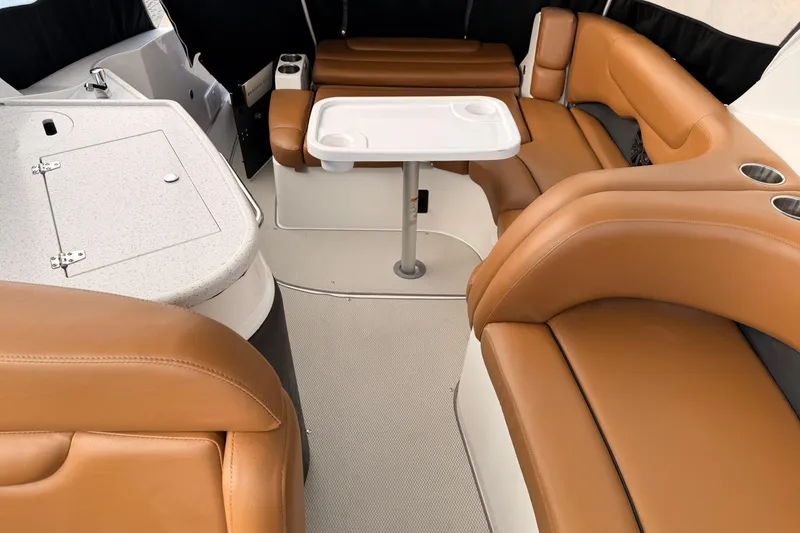 Slide: The Image of 2019 Rinker EX 290 boat interior with tan leather seating and a white table. - 7