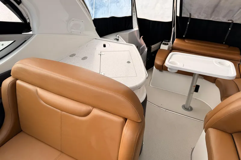 Slide: The Image of 2019 Rinker EX 290 boat interior with tan leather seating and a white table. - 8
