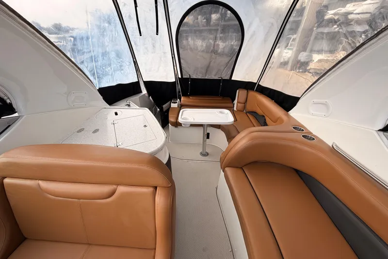 Slide: The Image of 2019 Rinker EX 290 boat interior with tan leather seating and a small table. - 9