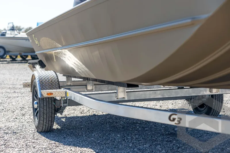 Slide: The Image of 2026 G3 Gator Tough 1860 VBW boat on trailer, parked on gravel. - 13