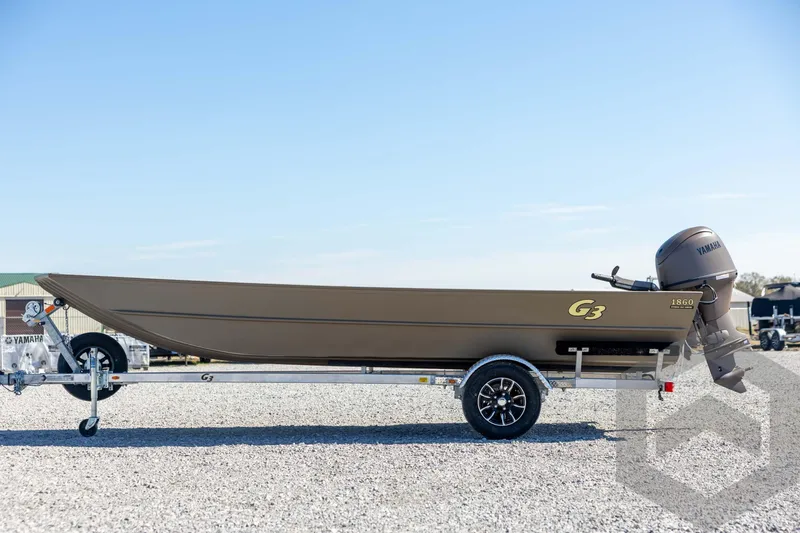 Slide: The Image of 2026 G3 Gator Tough 1860 VBW boat on trailer, side view, outdoors. - 8