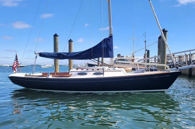 Slide: The Image of 2002 Alerion 28 Express sailboat docked in a marina under clear blue skies. - 0