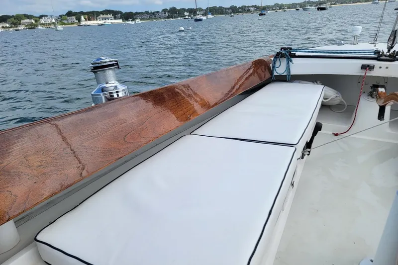 Slide: The Image of 2002 Alerion 28 Express sailboat with cushioned seating, docked on a calm waterfront. - 10