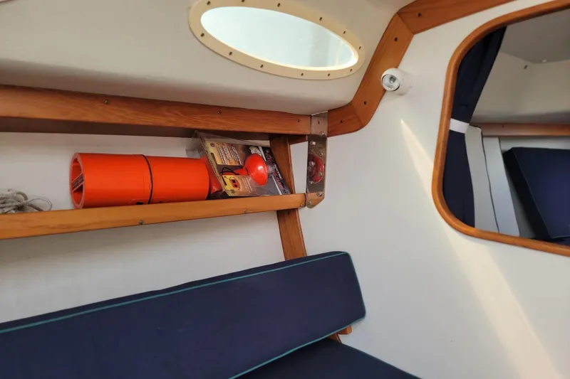 Slide: The Image of Interior of 2002 Alerion 28 Express sailboat with wooden shelves and safety equipment. - 11