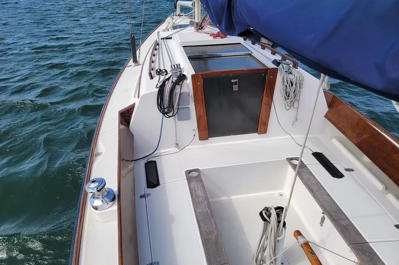 Slide: The Image of 2002 Alerion 28 Express sailboat deck with ropes and winch on open water. - 13
