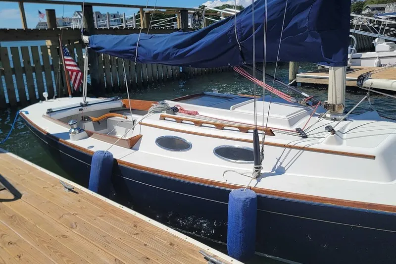 Slide: The Image of 2002 Alerion 28 Express sailboat docked with blue sail cover and American flag. - 16