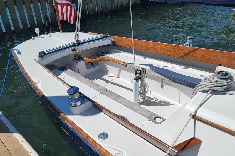 Slide: The Image of 2002 Alerion 28 Express sailboat with wooden trim, docked by the water. - 9