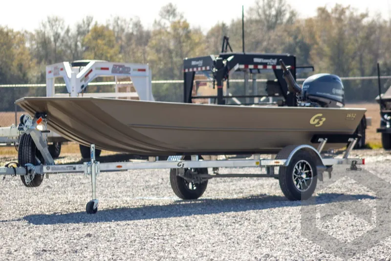 The Image of 2026 G3 Gator Tough 1652 VBW boat on trailer, outdoors, with Yamaha motor. - 1